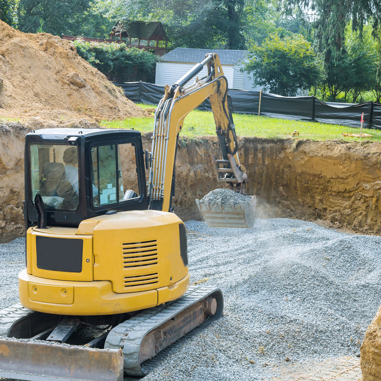 excavator pouring rock foundation delivered by tkm materials for home