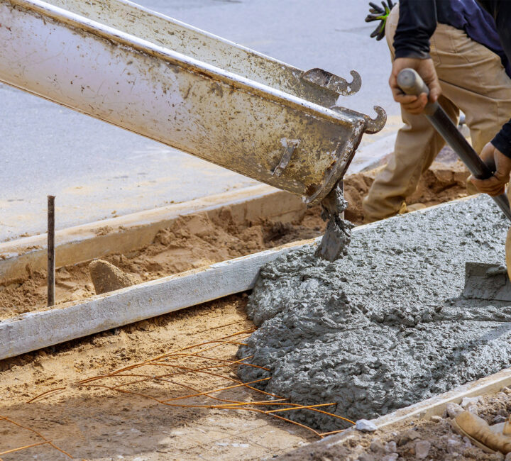 workers at construction site spreading concrete delivered by tkm materials