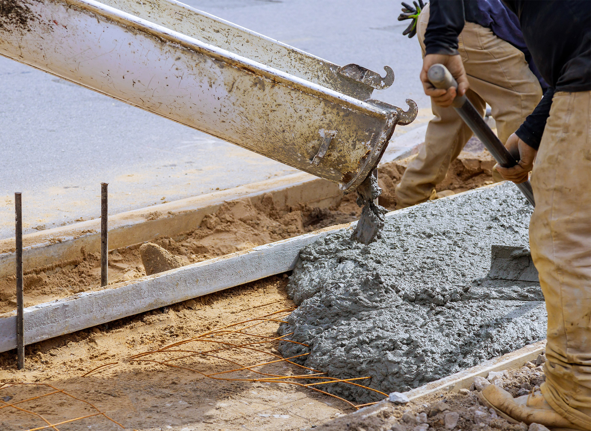 workers at construction site spreading concrete delivered by tkm materials